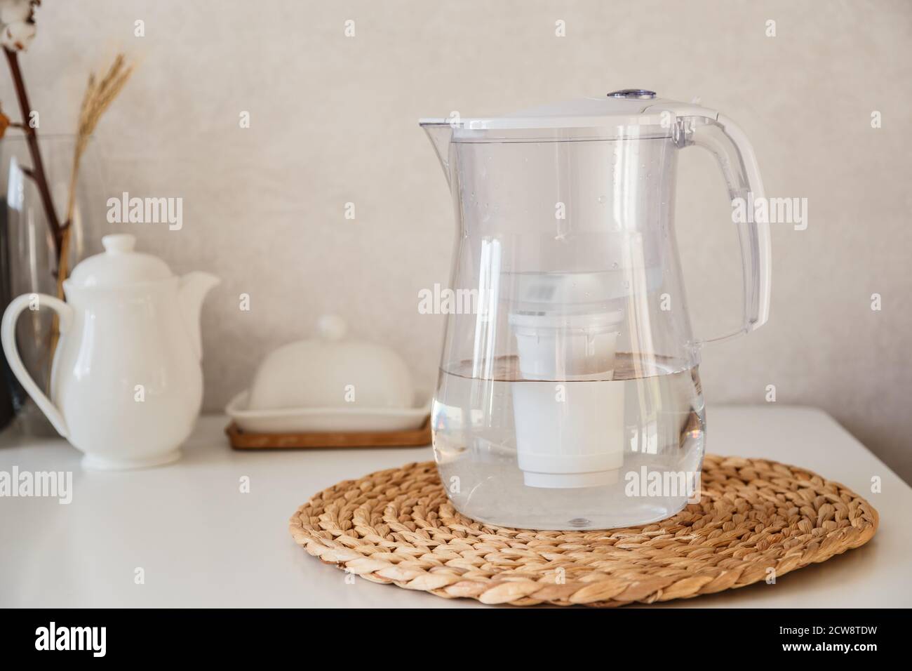 Glas und Kanne mit frischem Wasser auf dem Tisch im Kintchen Stockfoto