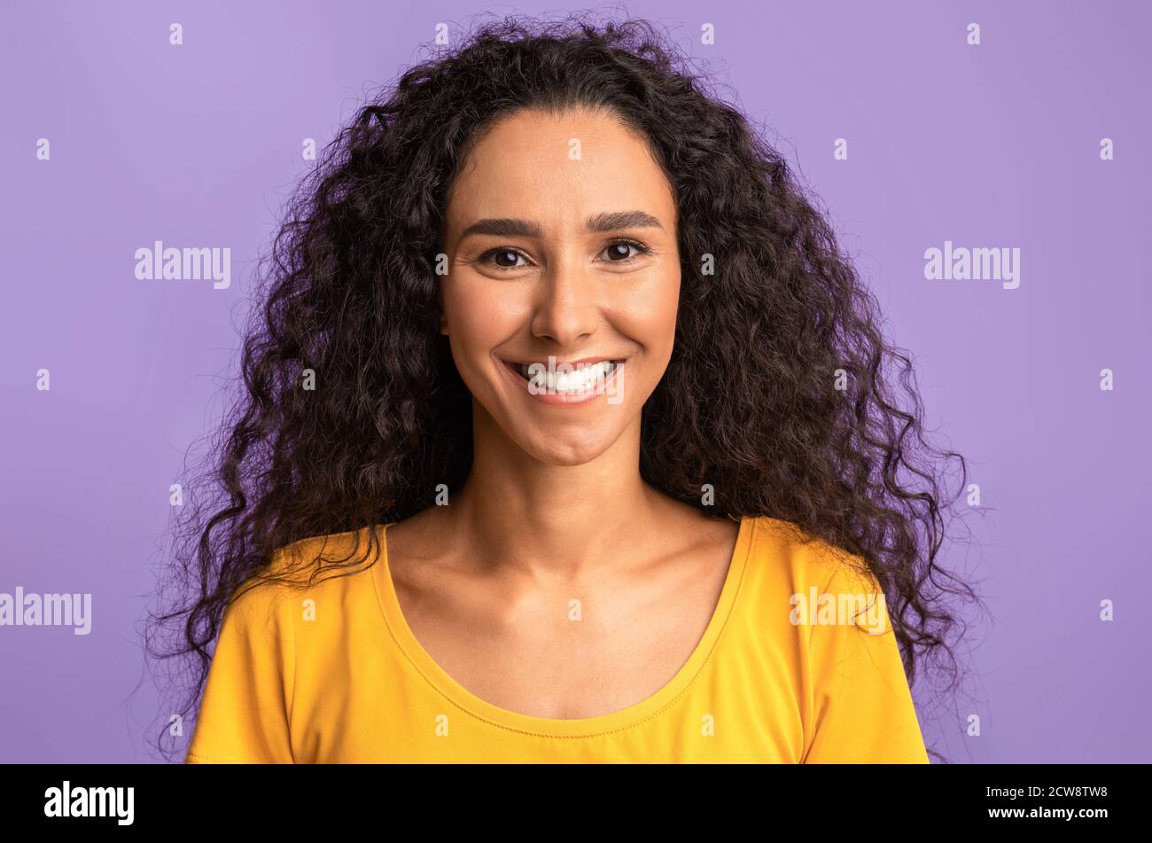 Glückliche Person. Porträt einer lächelnden Frau mit gebräunter Haut und lockiges Haar Stockfoto