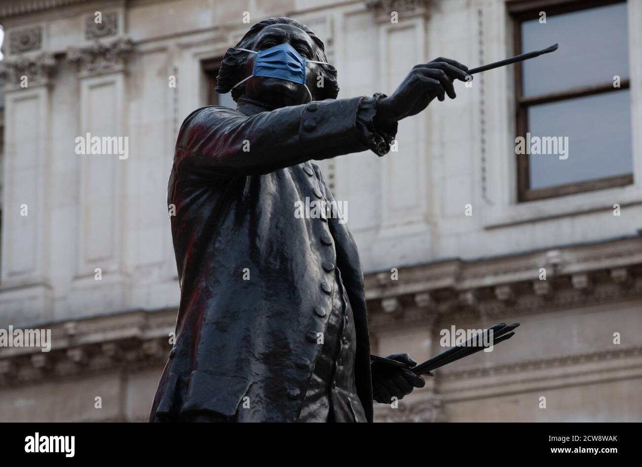 Statue von Joshua Reynolds mit Covid Maske im Annenburg Hof im Burlington Haus. Er war der erste Präsident der Royal Academy Stockfoto