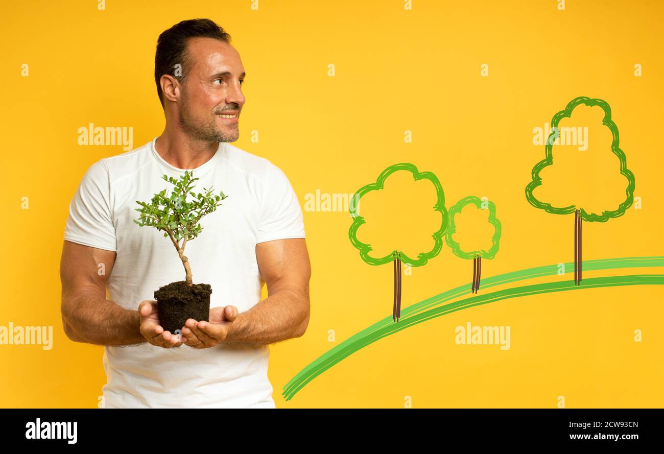 Happy man hält einen kleinen Baum bereit, gepflanzt werden. Konzept der Aufforstung, Ökologie und Erhaltung Stockfoto