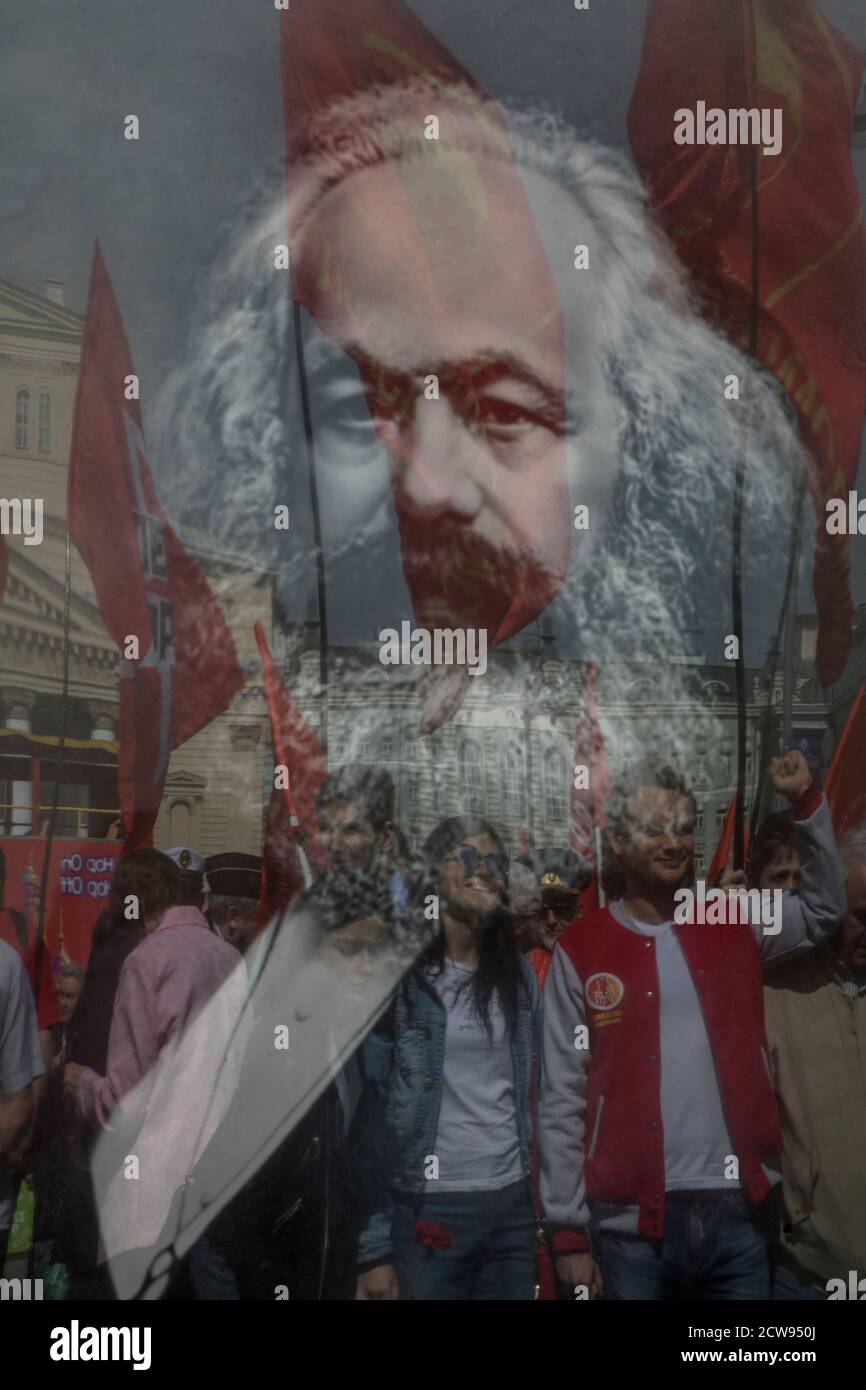 Moskau, Russland. 5. Mai 2018 Menschen halten ein Porträt von Karl Marx und legen Blumen an der Gedenkstatue von Karl Marx während der Feierlichkeiten zum 200. Jahrestag seiner Geburt, in Moskau, Russland Stockfoto