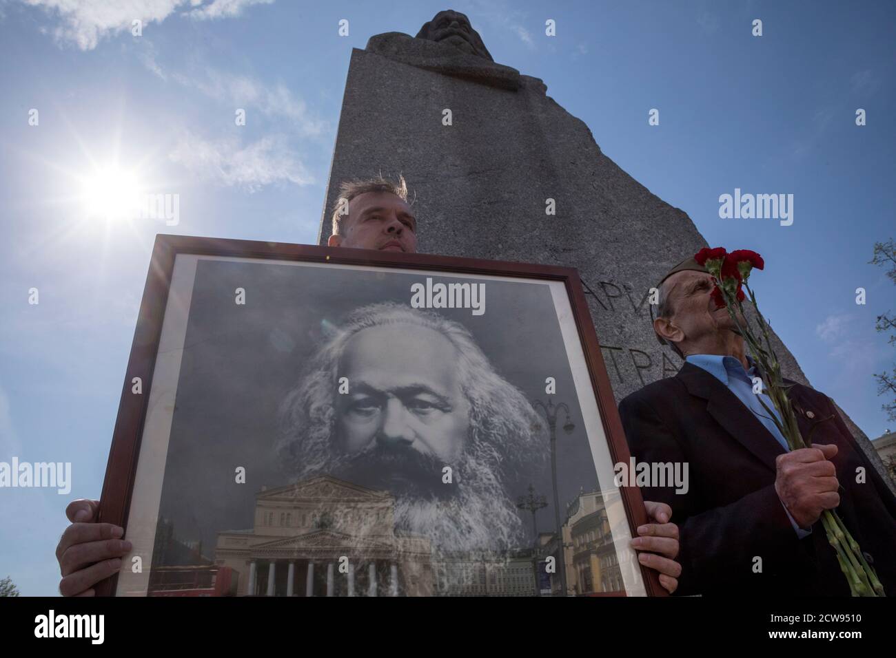 Moskau, Russland. 5. Mai 2018 Menschen halten ein Porträt von Karl Marx und legen Blumen an der Gedenkstatue von Karl Marx während der Feierlichkeiten zum 200. Jahrestag seiner Geburt, in Moskau, Russland Stockfoto