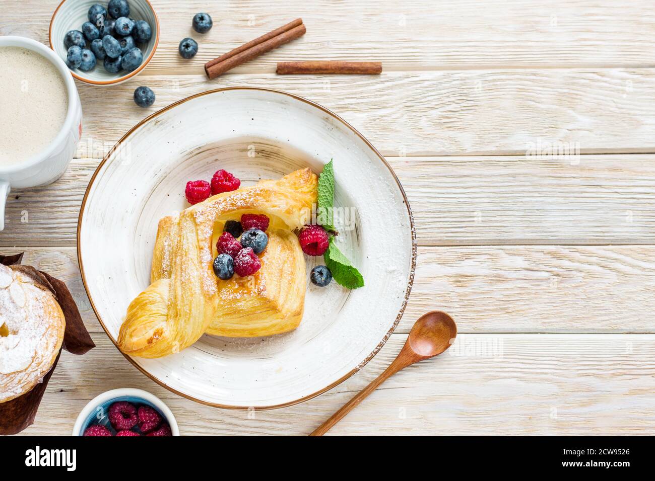 Köstliches süßes Gebäck aus Blätterteig. Kuchen mit frischen Beeren auf einem Holzhintergrund. Gewürz kopieren Stockfoto