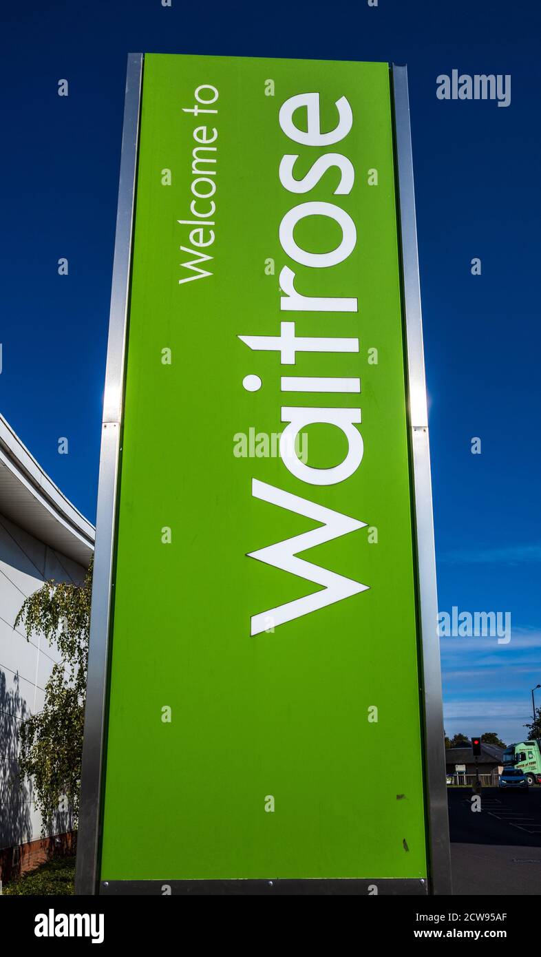 Waitrose Supermarkt Zeichen - Zeichen vor einem Waitrose Supermarkt gegen einen blauen Himmel. Stockfoto