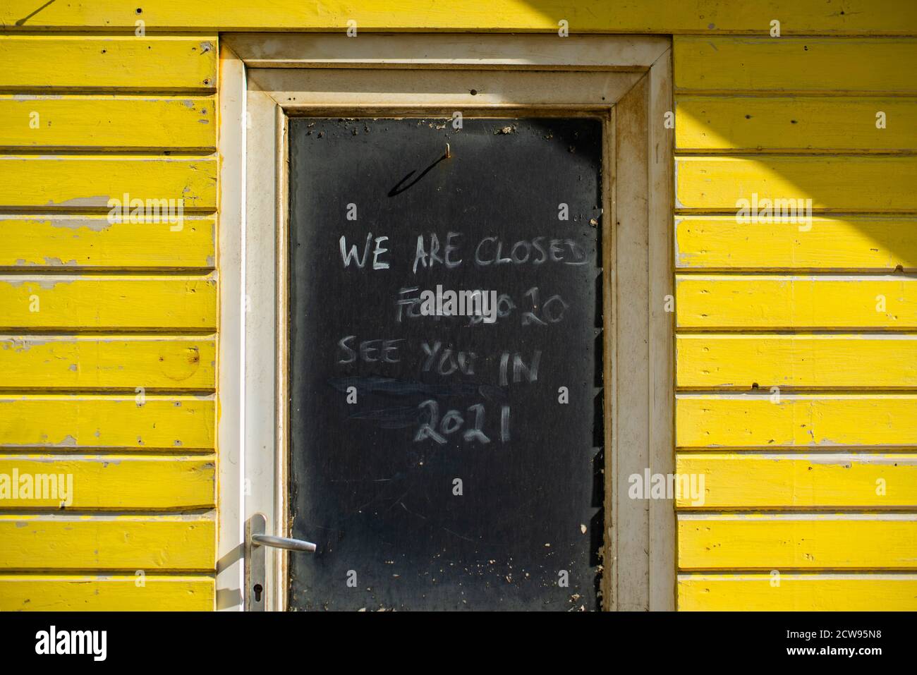 Ein Schild an einer geschlossenen Tür einer Strandhütte Sagen: „Wir sind für 2020 bis 2021 geschlossen.“ Auf der Isle of Wight Stockfoto