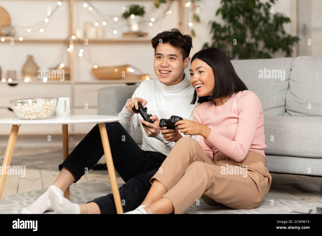 Chinesische Freundin Und Freund Spielen Videogame Bei Zu Hause Stockfoto