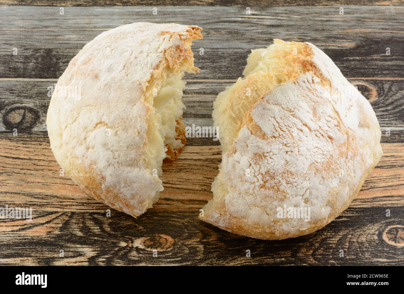 Gebrochenes rundes Brot auf dem Tisch als Symbol für Geweihtes Brot für die Kommunion Stockfoto