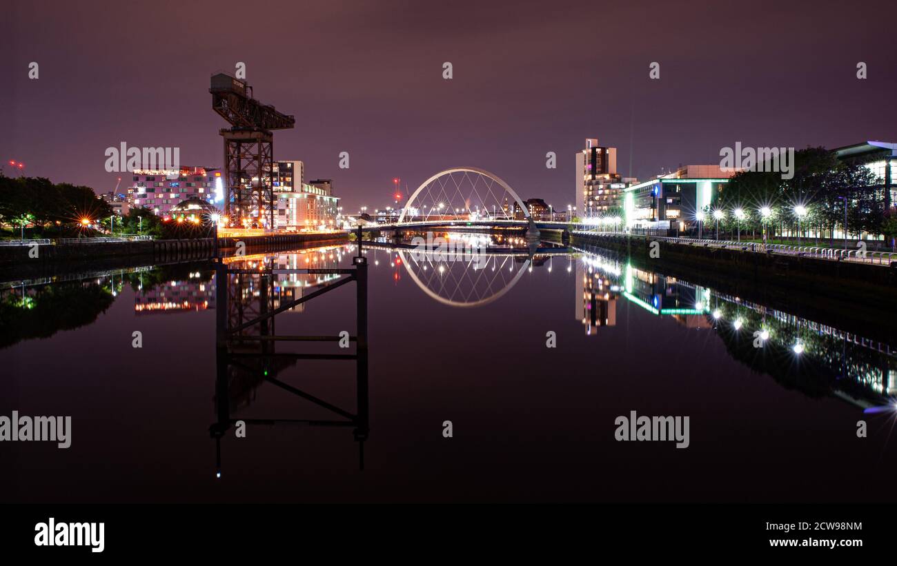 Ein perfekt stilles River Clyde bei Nacht, Glasgow, Schottland. Reflexionen des titan-Krans und des clyde-Bogens funkeln im Wasser Stockfoto