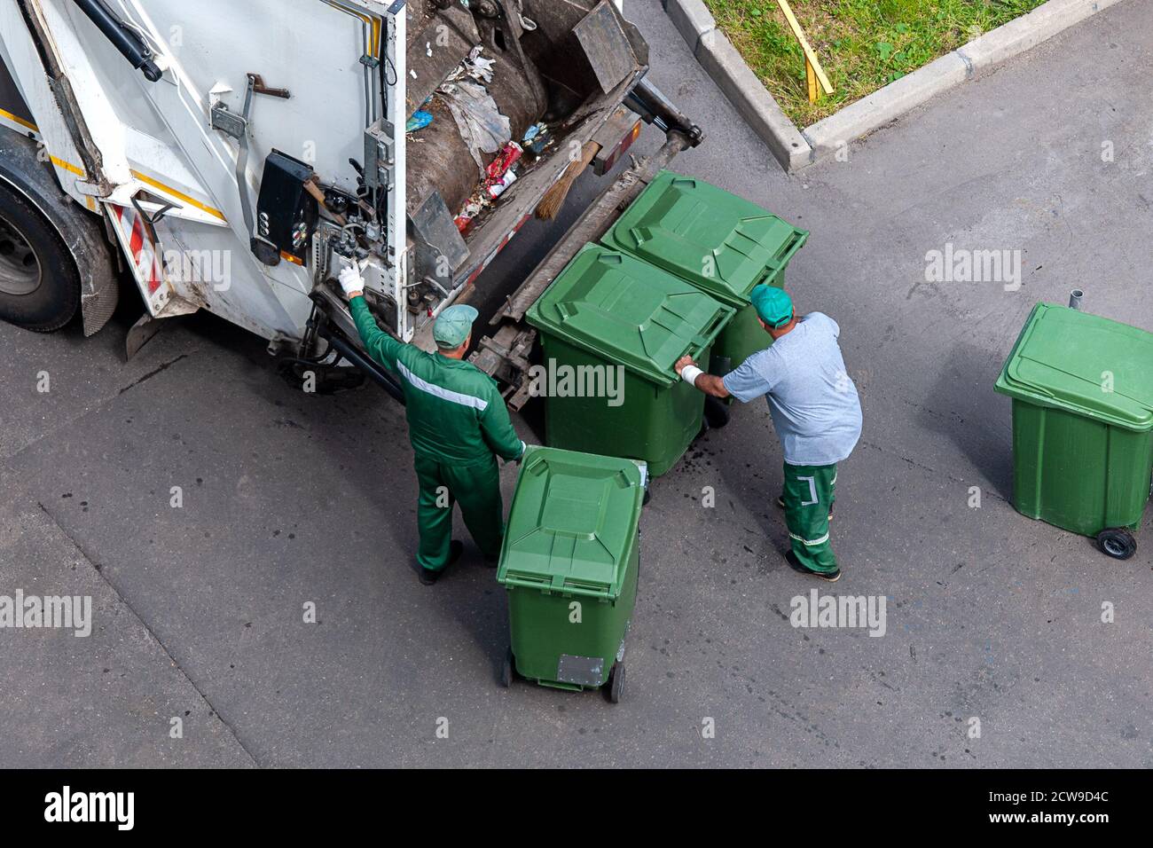 Müllmänner laden Hausmüll in Müllwagen, Blick von oben Stockfoto