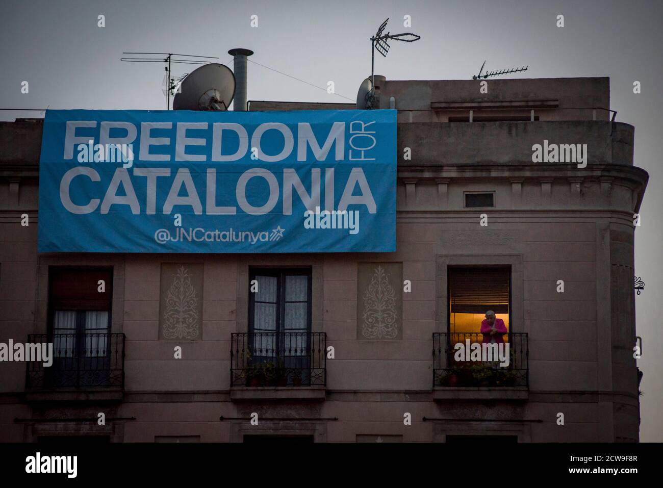 Barcelona Spanien. September 2020. In Barcelona blickt eine Frau von einem Balkon aus hinüber, als auf einem Transparent steht: "Freiheit für Katalonien". Der spanische Oberste Gerichtshof hat den katalanischen Präsidenten Quim Torra wegen Ungehorsams disqualifiziert. Quelle:Jordi Boixareu/Alamy Live News Stockfoto