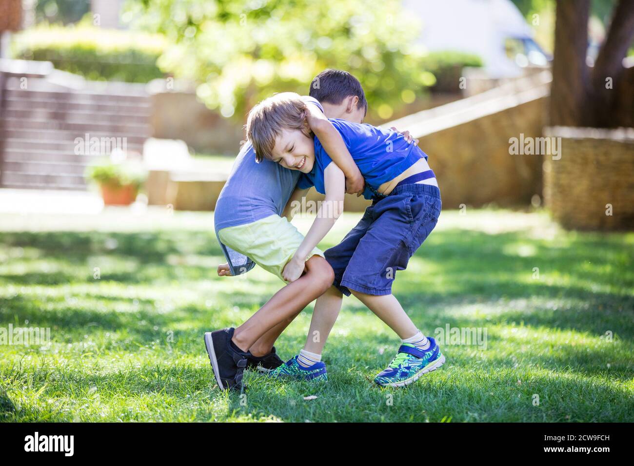 Zwei Jungen kämpfen im Freien. Geschwister oder Freunde ringen im Sommerpark. Rivalität der Geschwister. Stockfoto