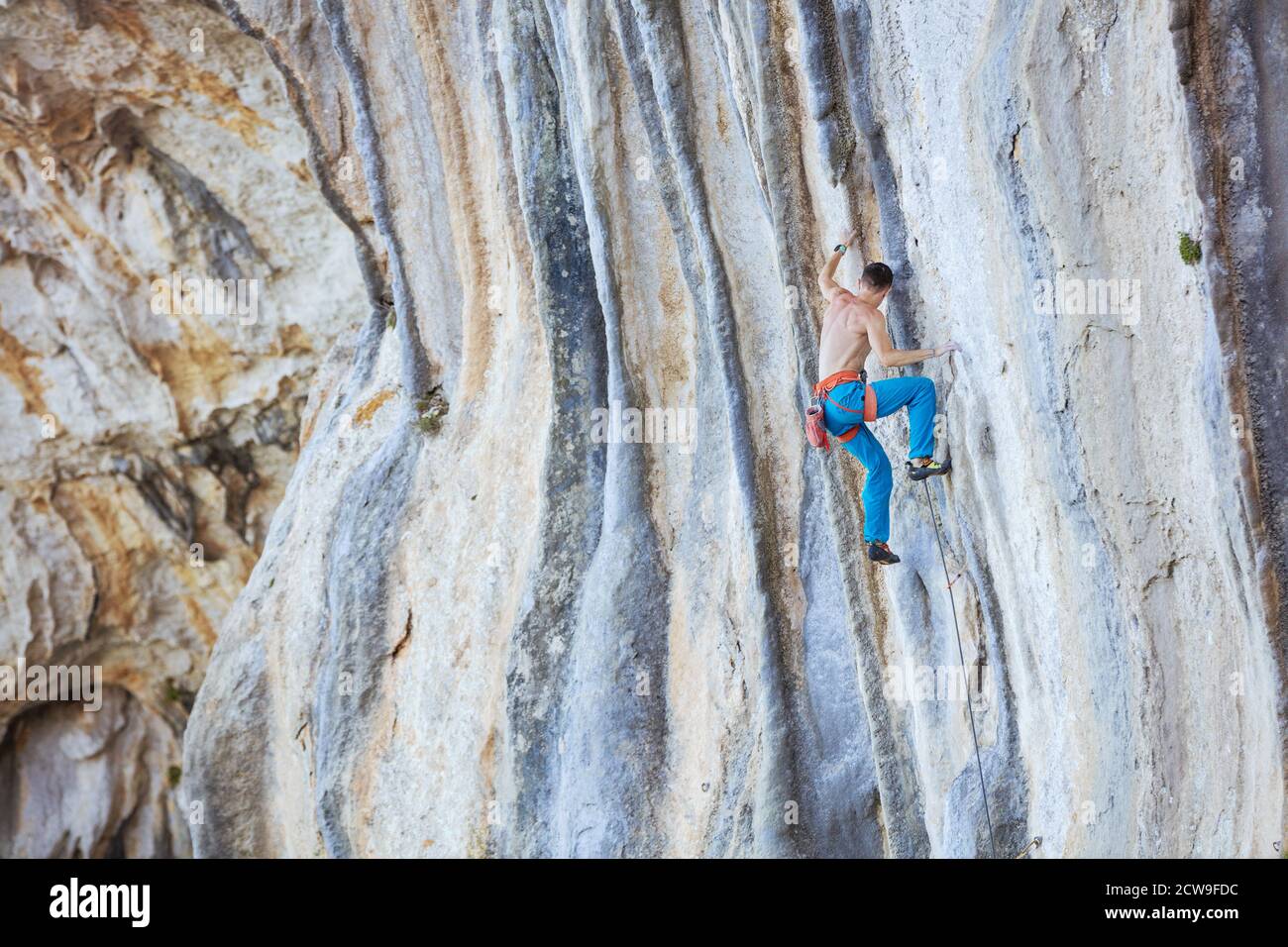 Kaukasischer junger Mann, der eine schwierige Route auf einer Klippe erklimmt Stockfoto