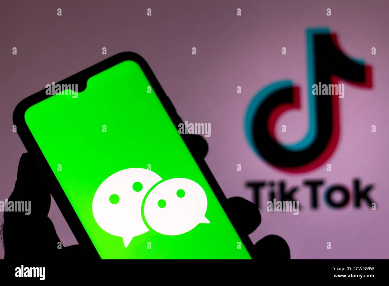 In dieser Abbildung ist ein WeChat-Logo auf einem Smartphone mit einem TikTok-Logo auf dem Hintergrund zu sehen. Stockfoto