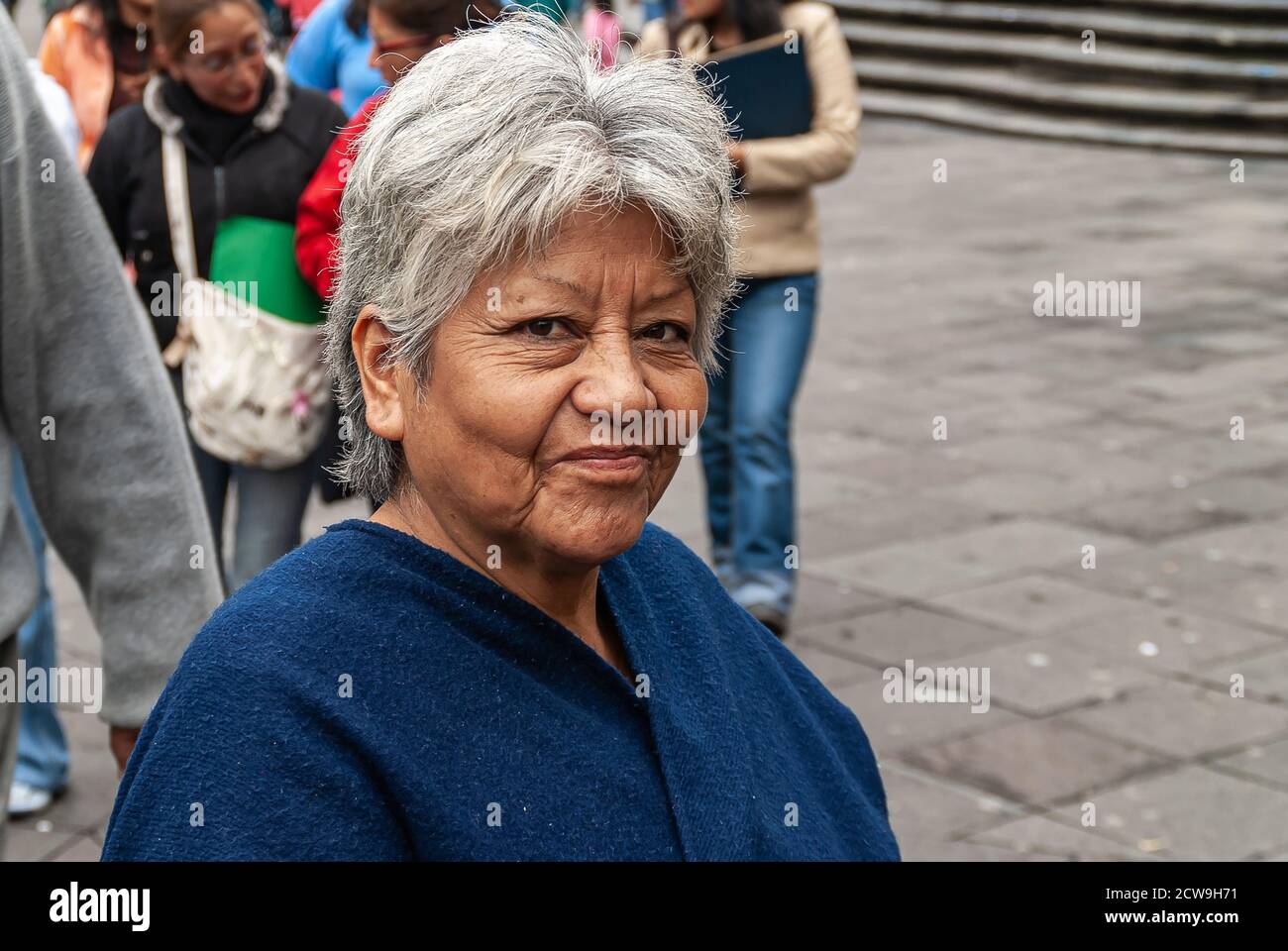 Quito, Ecuador - 2. Dezember 2008: Historische Innenstadt. Nahaufnahme einer lächelnden und grauenden Frau mit blauer Weste. Stockfoto