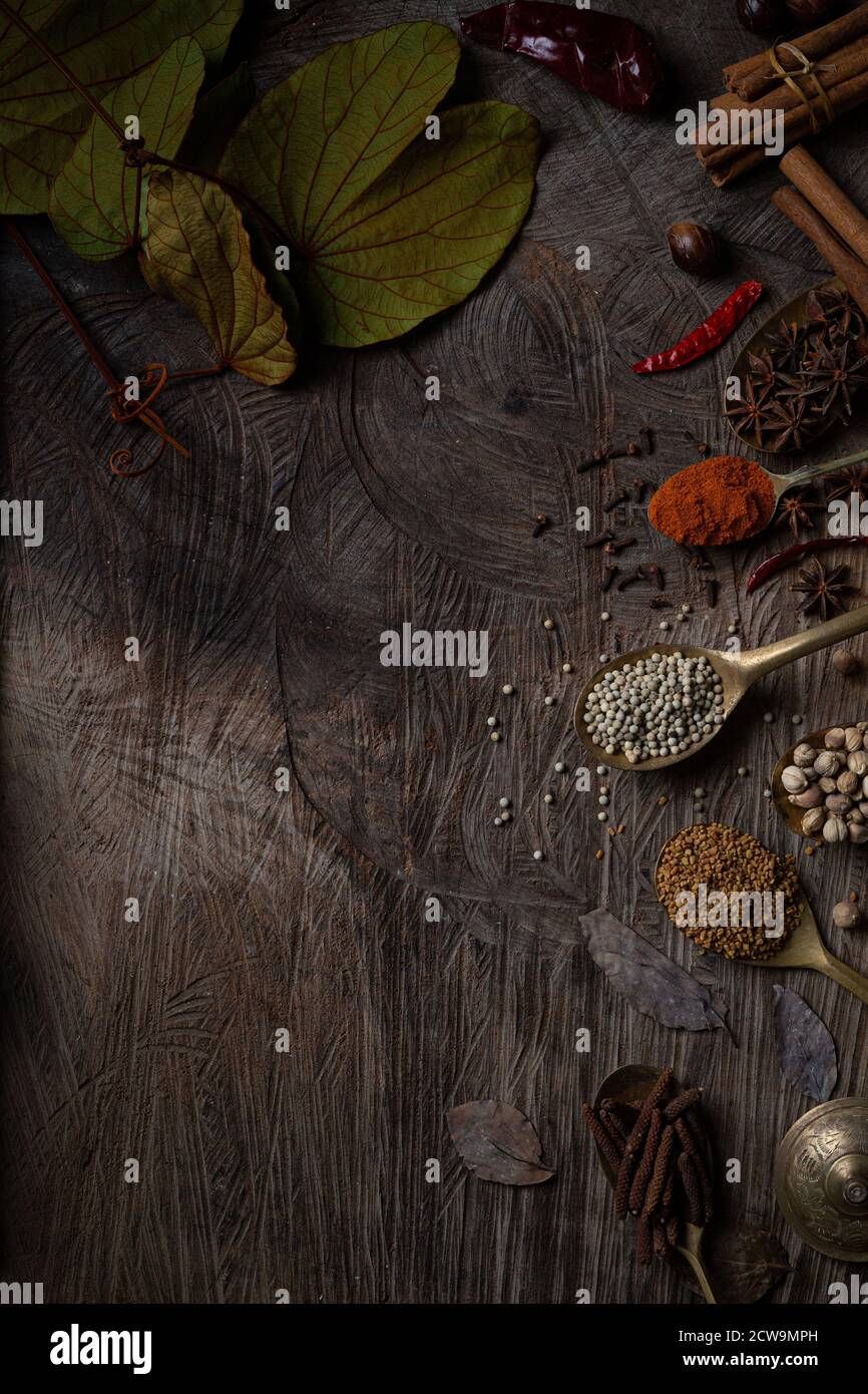 Würze von indischem Essen Gewürzgarnitur Hintergrund auf Holztisch Draufsicht. Würze der asiatischen Bio-Kräuter-Küche Geschmack in der Küche Bord, Chili. Stockfoto