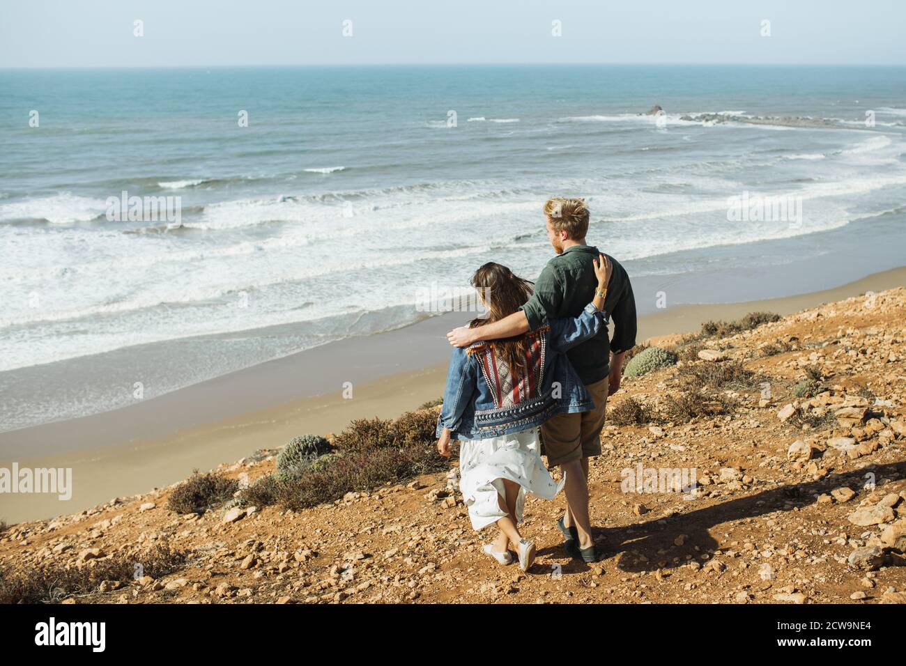 Junge stilvolle unkenntlich Paar zu Fuß mit herrlichem Meerblick. Rückansicht von hinten. Reisekonzept, Ort für Text. Flitterwochen in den Tropen. Stockfoto