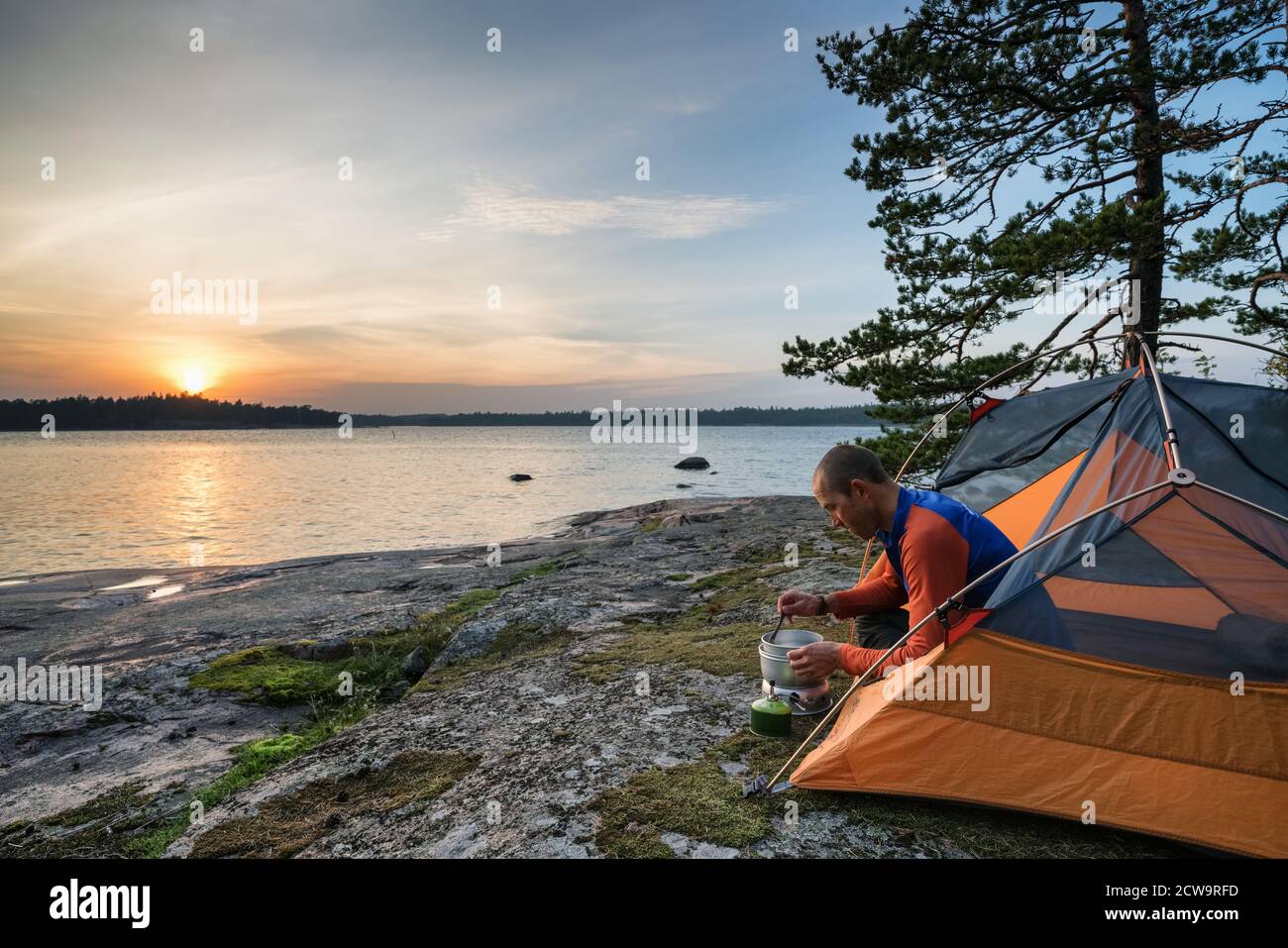 Kochen Abendessen bei Sonnenuntergang auf Hommanskär Insel, Kirkkonummi, Finnland Stockfoto