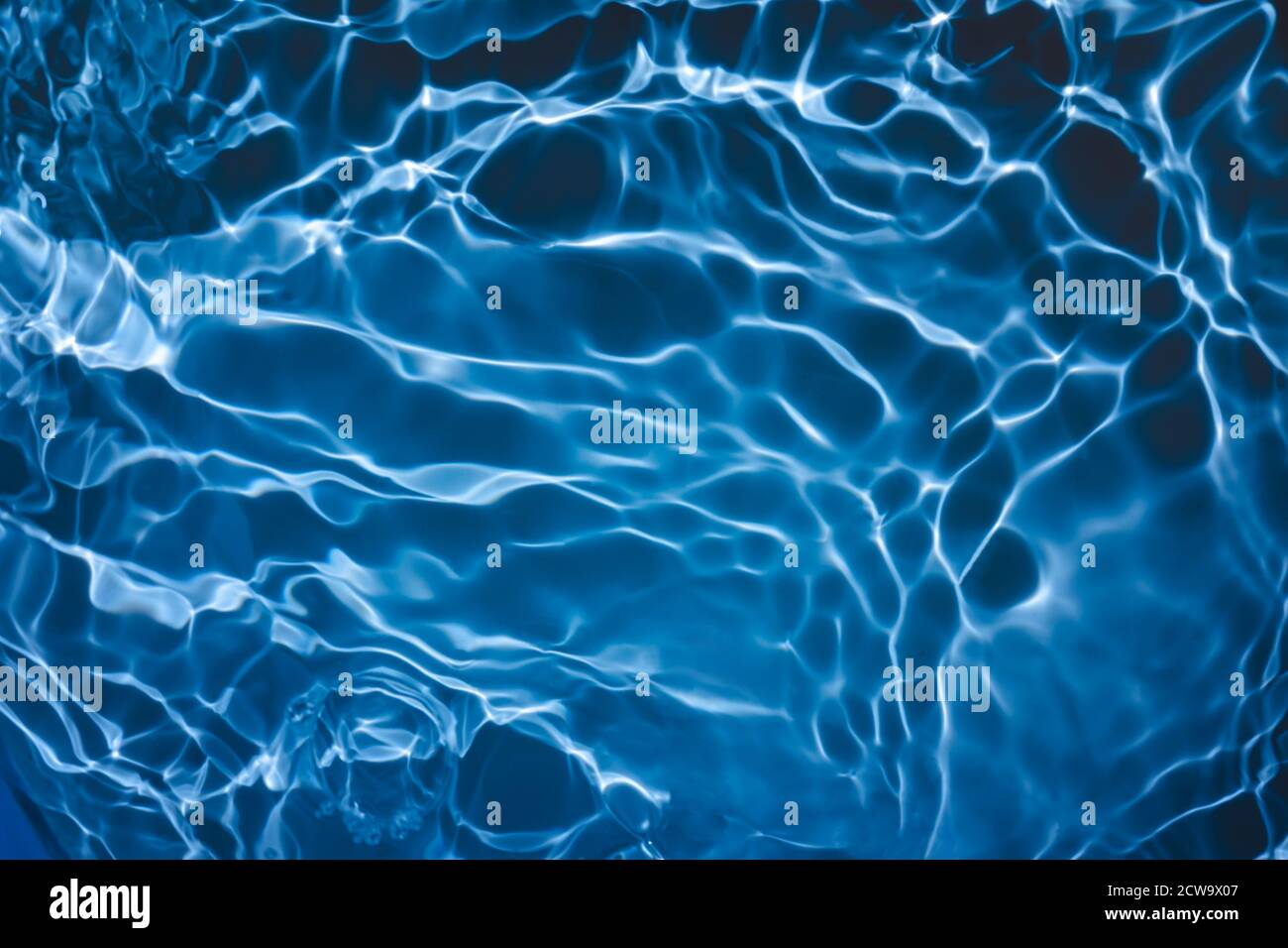 Transparent dunkelblau gefärbt klar ruhig Wasser Oberflächenstruktur Stockfoto