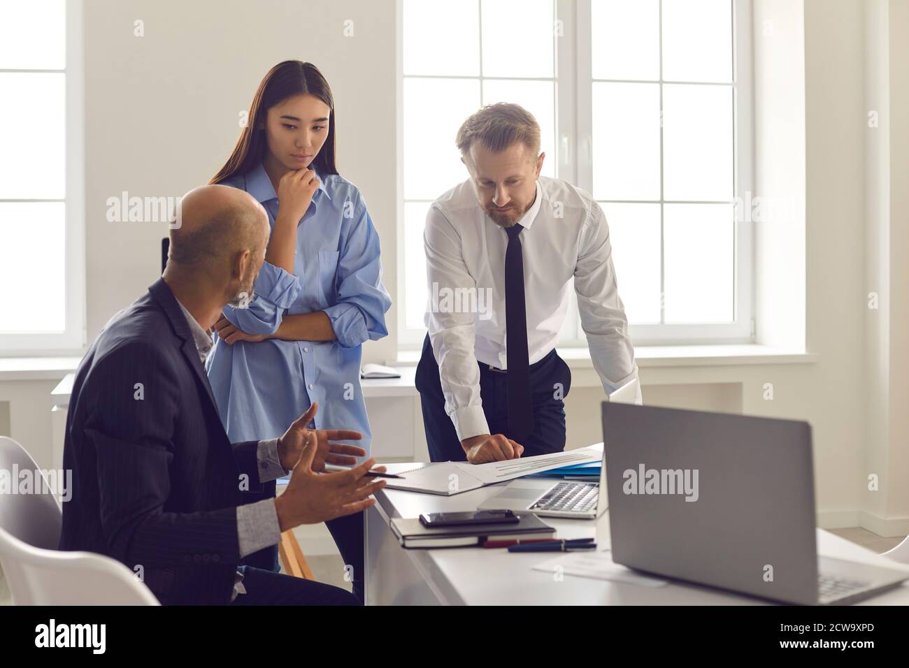 Seriöse Mitarbeiter hören beim Lösen auf die Ratschläge und Anweisungen des Vorgesetzten Arbeitsprojekt Problem Stockfoto