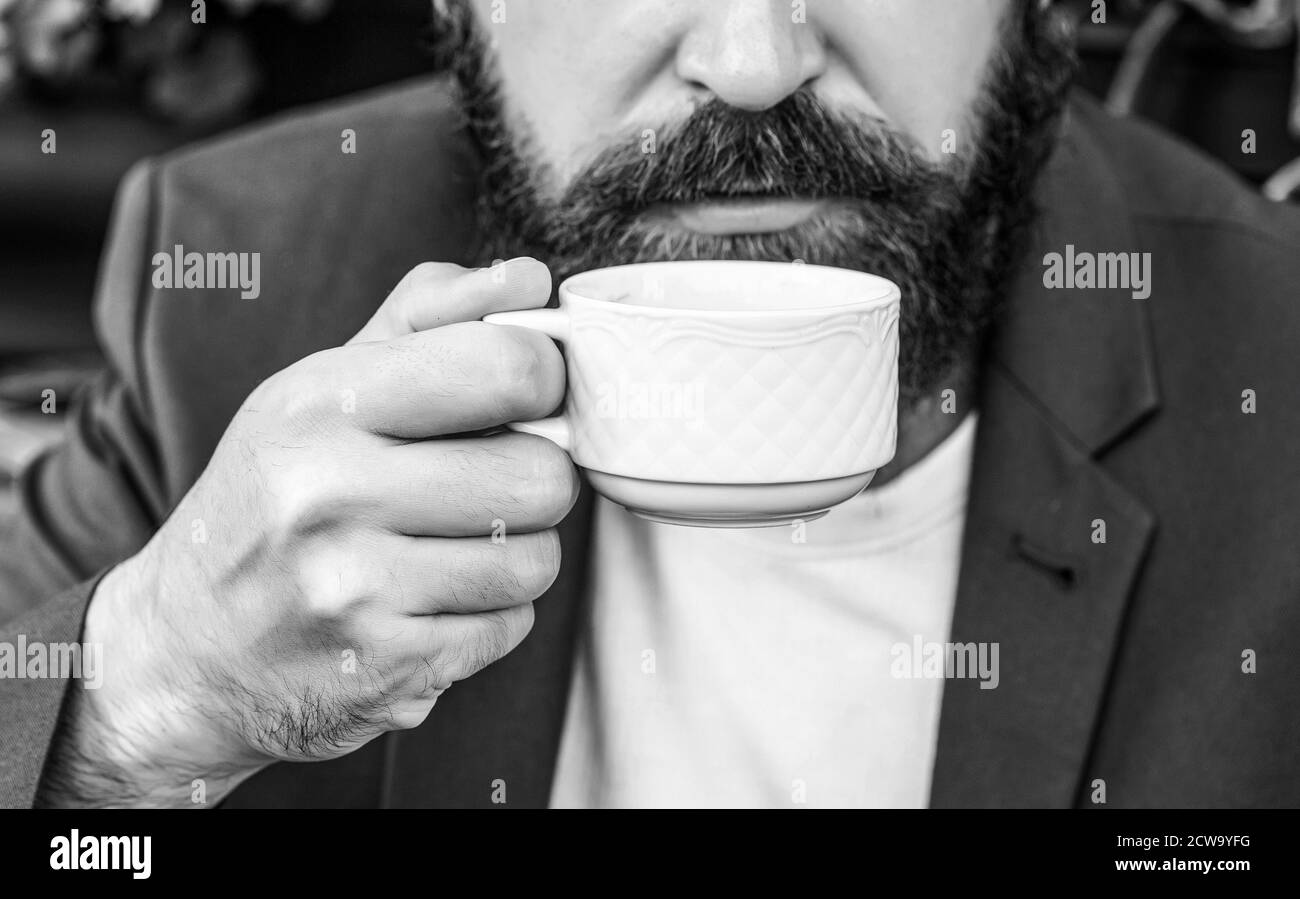 Kaffeegetränk. Bärtiger Mann, Hände mit heißen Kaffeetassen. Kaffeezeit. Schwarz und Weiß Stockfoto