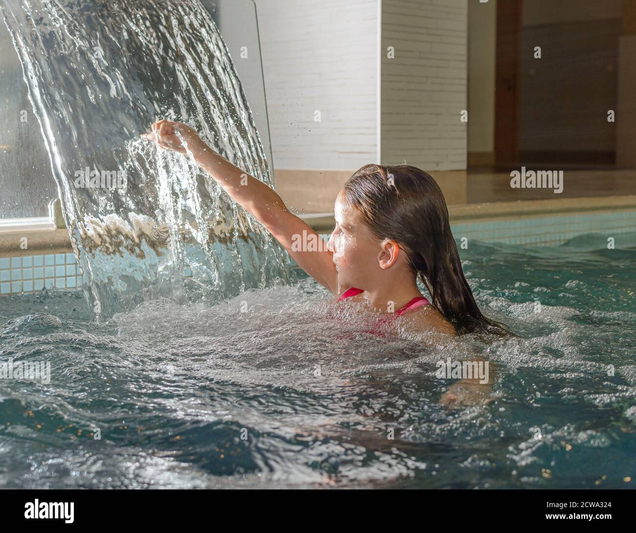 Junge schöne Teenager-Mädchen in Thermalbad entspannen unter fließendem Wasser Strom der Dusche. Gesunder Lebensstil Stockfoto