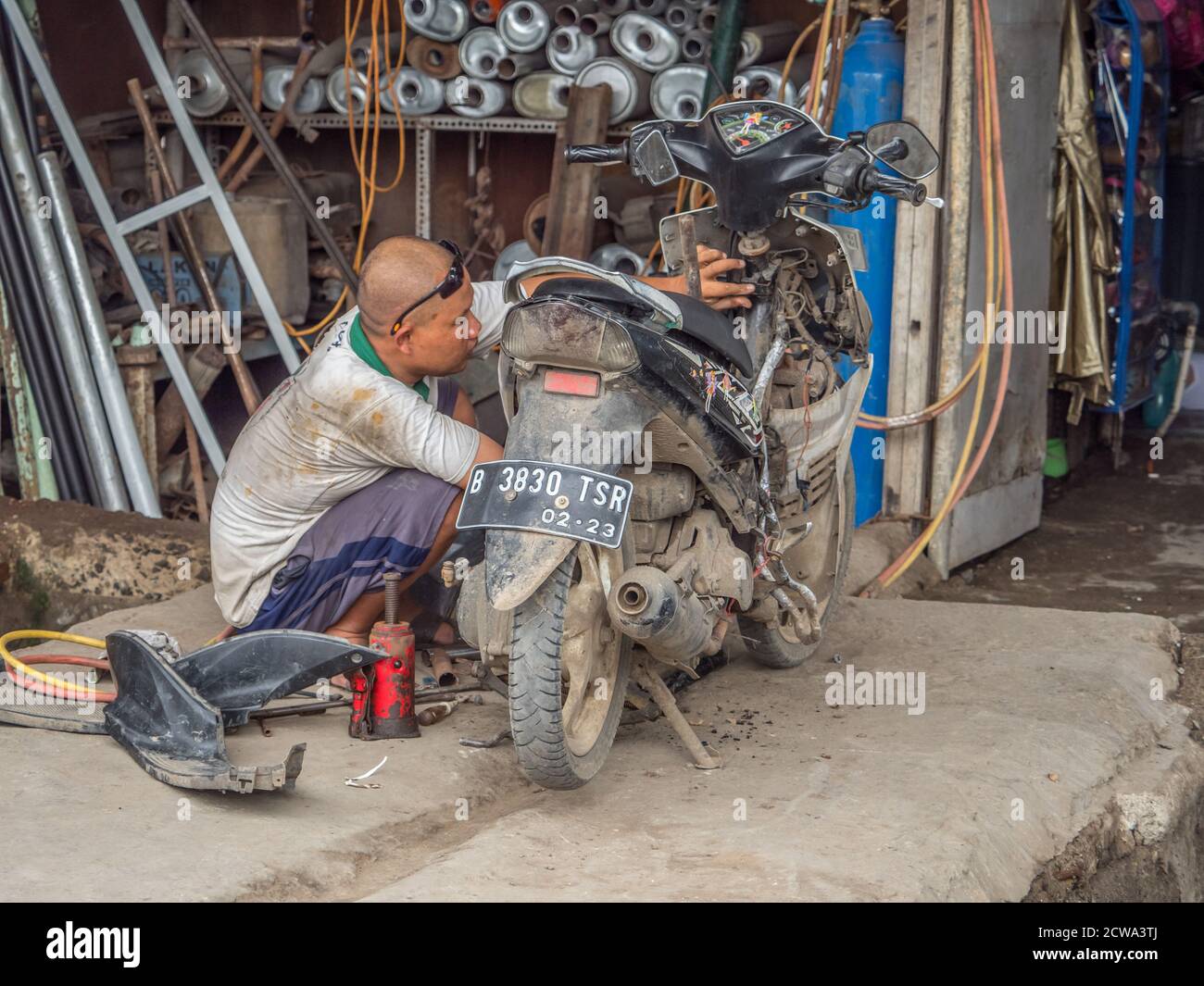 Jakarta, Indonesien - 20. Februar 2018: Mann repariert das Motorrad (ojek) auf der Straße von Jakarta. Stockfoto