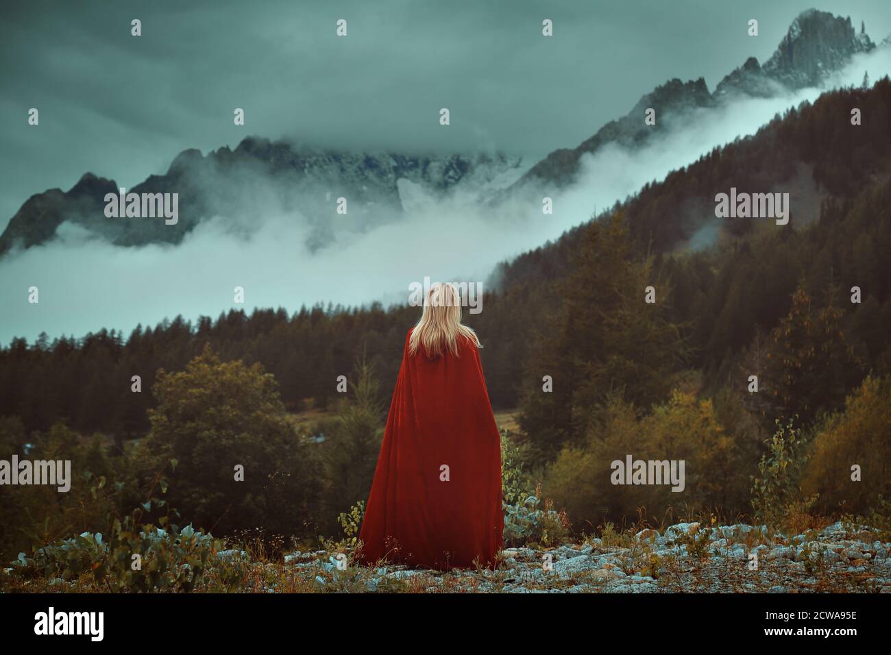 Frau mit rotem Mantel Blick nebligen Bergen Stockfoto