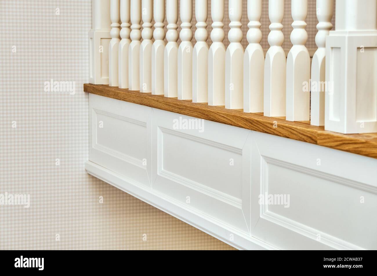 Weiße Balustrade. Balkon Holzgeländer mit weißen Balustern in einem hellen großen Raum Stockfoto
