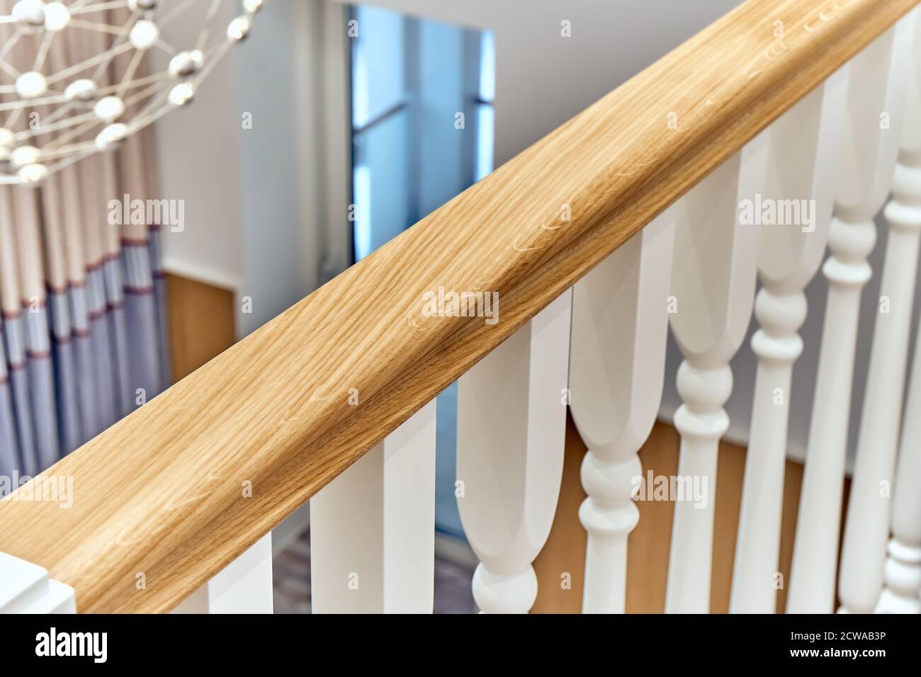 Weiße Balustrade. Balkon Holzgeländer mit weißen Balustern in einem hellen großen Raum Stockfoto