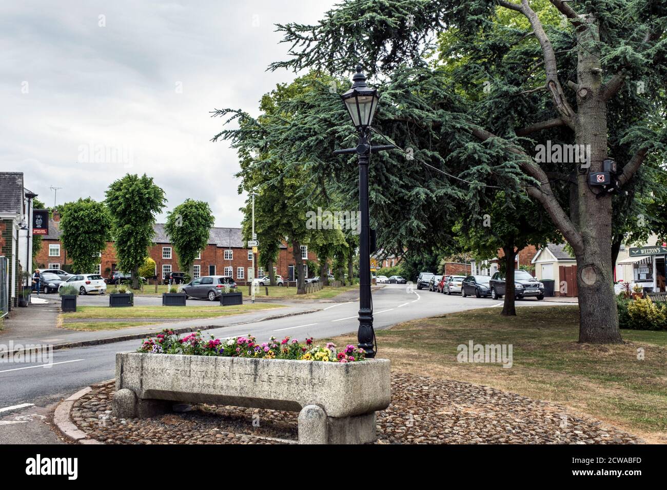 Steinrindtrog mit Blumen in Great Bowden Dorf, Leicestershire, England gepflanzt. Stockfoto