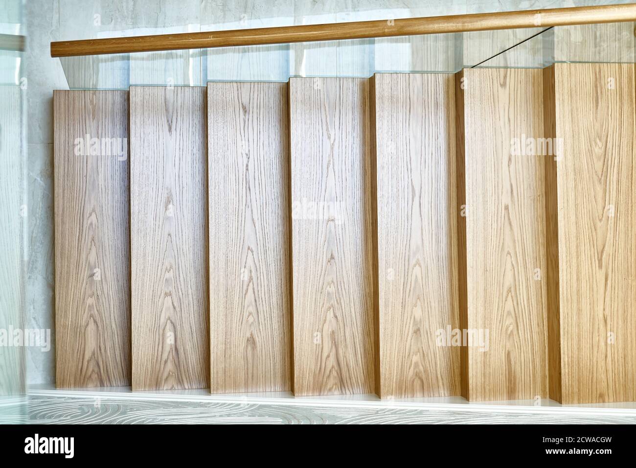 Holztreppe mit Glasgeländer und Holzgeländer. Blick von oben Stockfoto