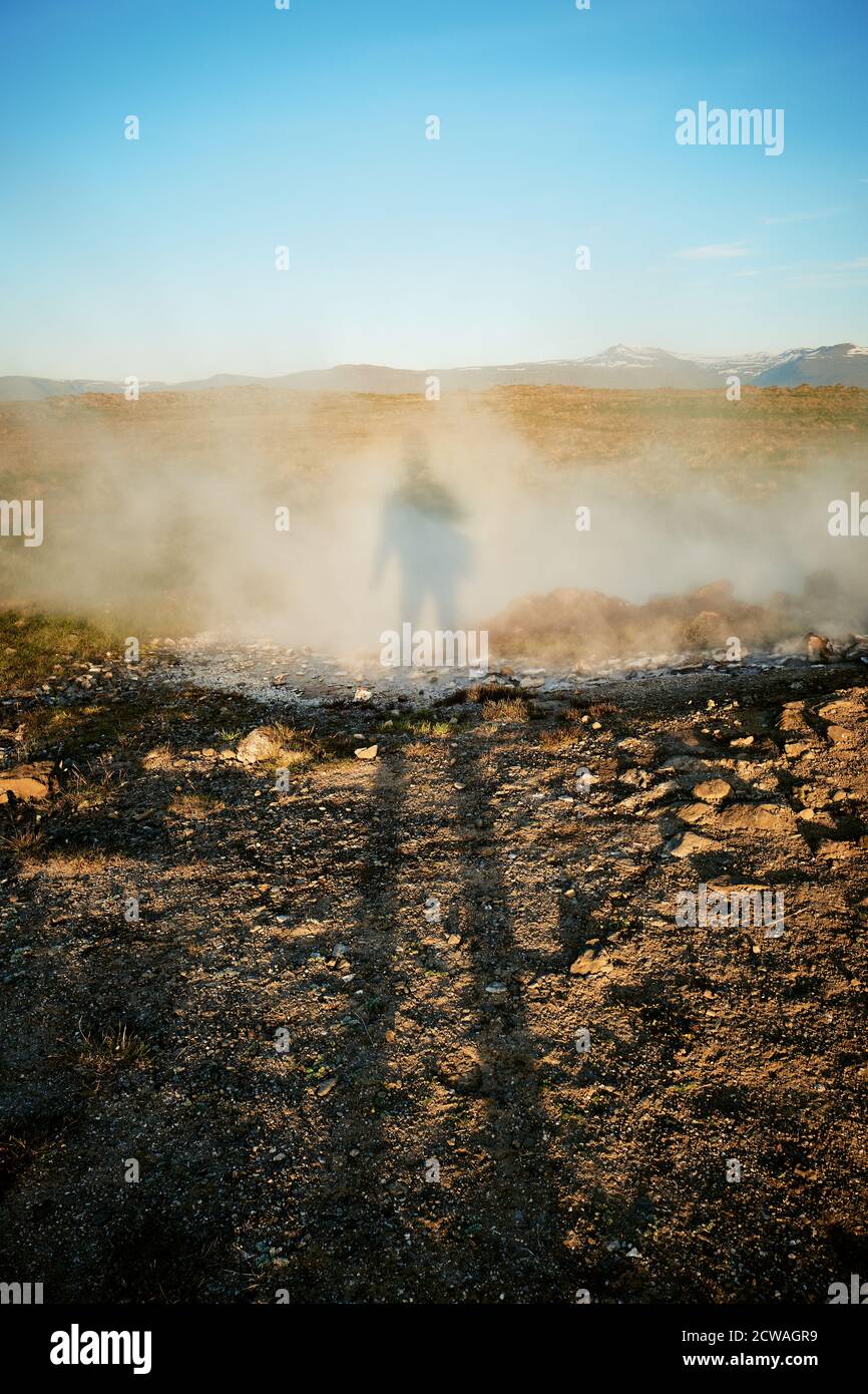 Eine hohe Schattenfigur im Dampf eines Naturs Geothermische Frühlingslandschaft in den Westfjorden von Island - Island Tourismus Stockfoto