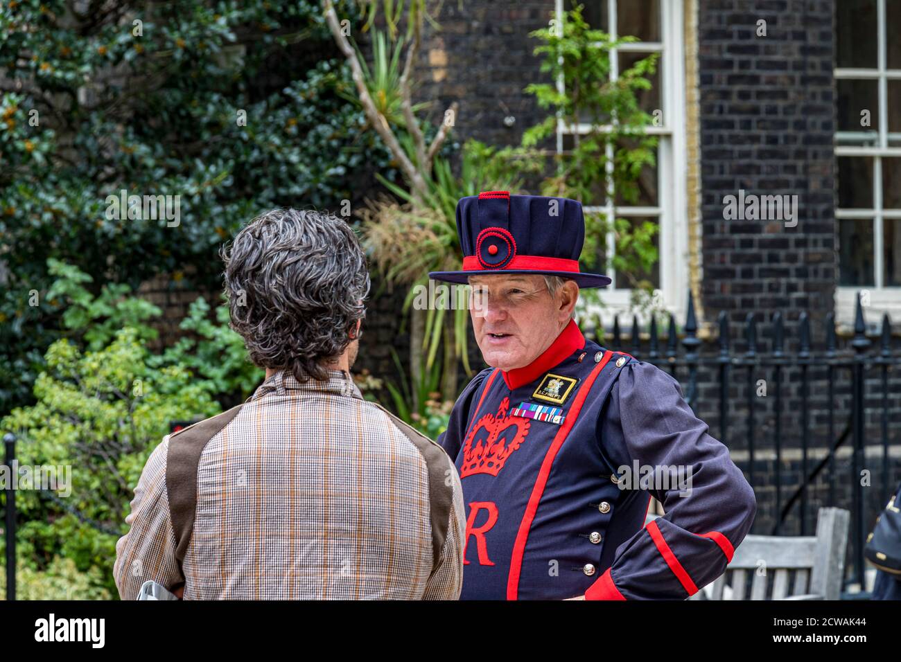Ein Yeoman Warder am Tower of London spricht mit einem Besucher, Tower of London, London EC3 Stockfoto