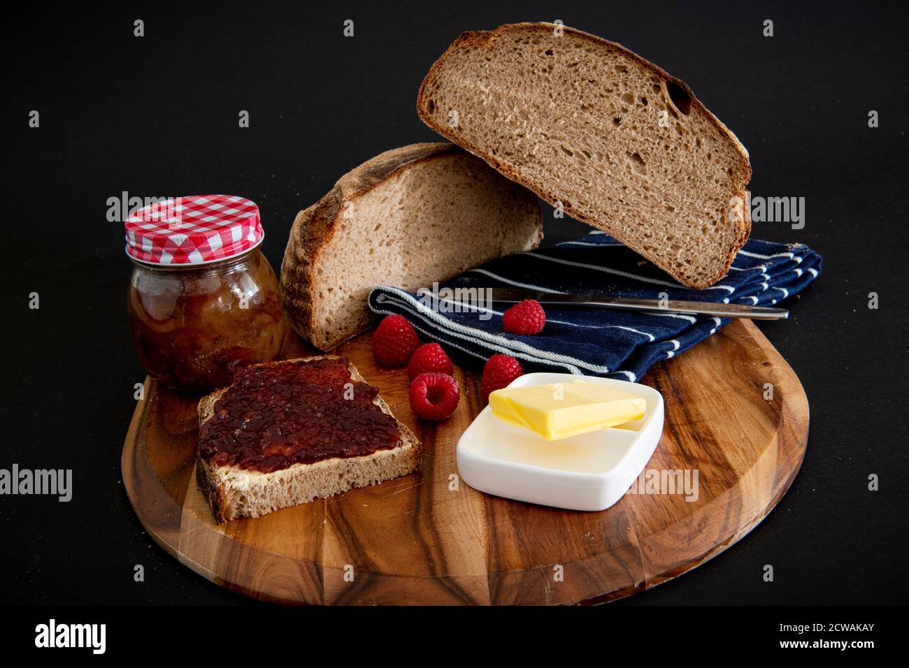 Roggenbrot auf einem Holzbrett mit schwarzem Hintergrund Stockfoto