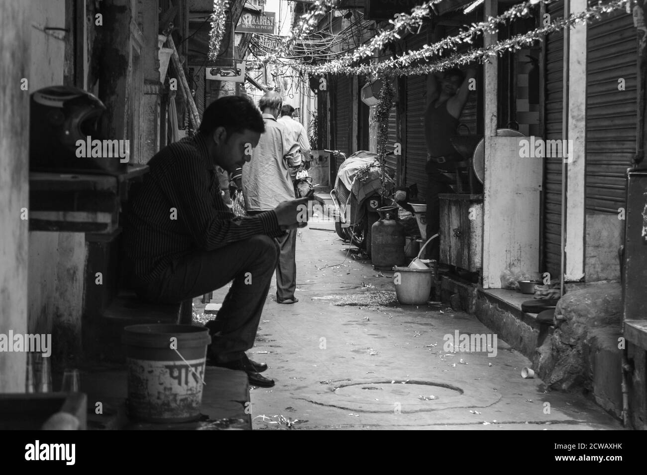 Ein Mann macht seine Arbeit auf verkehrsreichen Straßen in chandani chowk, Alt-delhi, indien. Stockfoto