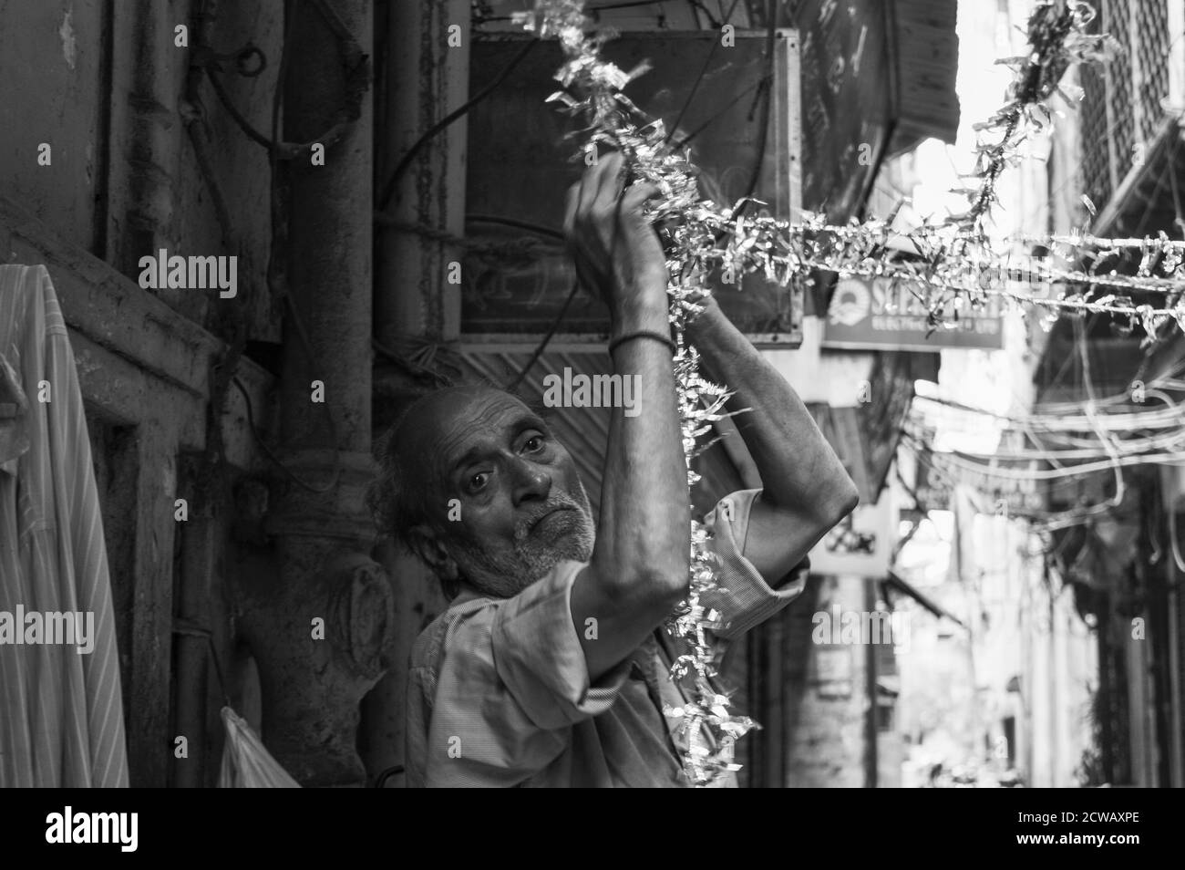 Ein Mann macht seine Arbeit auf verkehrsreichen Straßen in chandani chowk, Alt-delhi, indien. Stockfoto