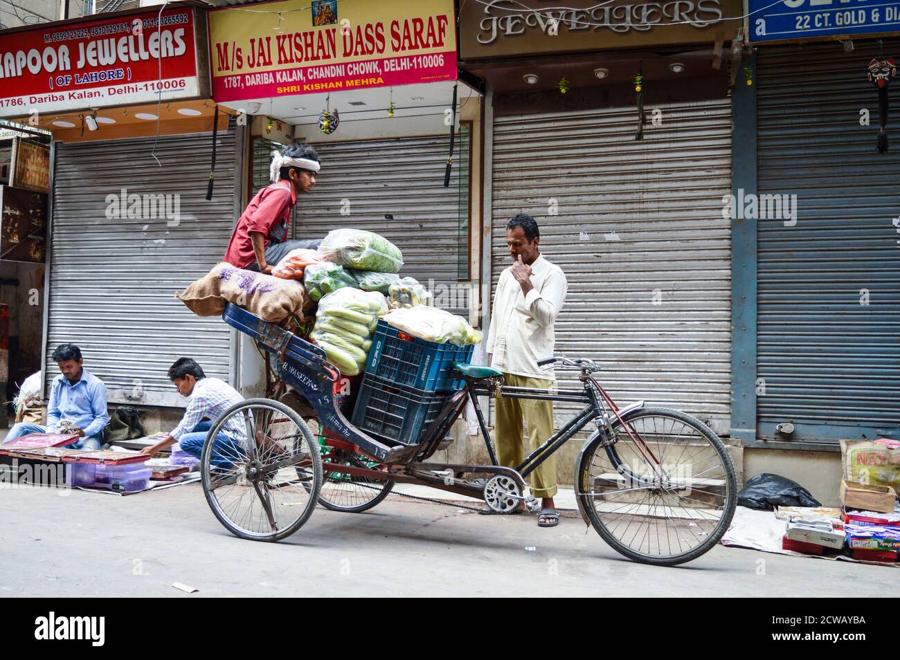 Ein Mann macht seine Arbeit auf verkehrsreichen Straßen in chandani chowk, Alt-delhi, indien. Stockfoto