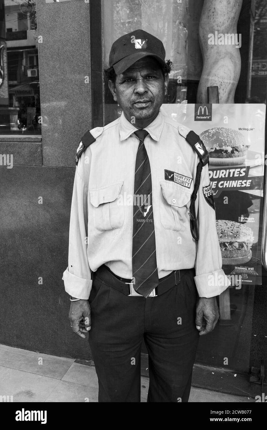 Ein Porträt eines alten Wachmanns steht außerhalb seines Arbeitsplatzes für Geld. Stockfoto