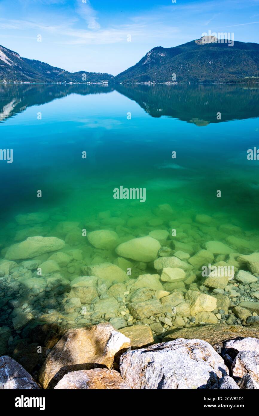 Steine und transparentes buntes Seenwasser gegen die Berge und Ihre Spiegelung Stockfoto