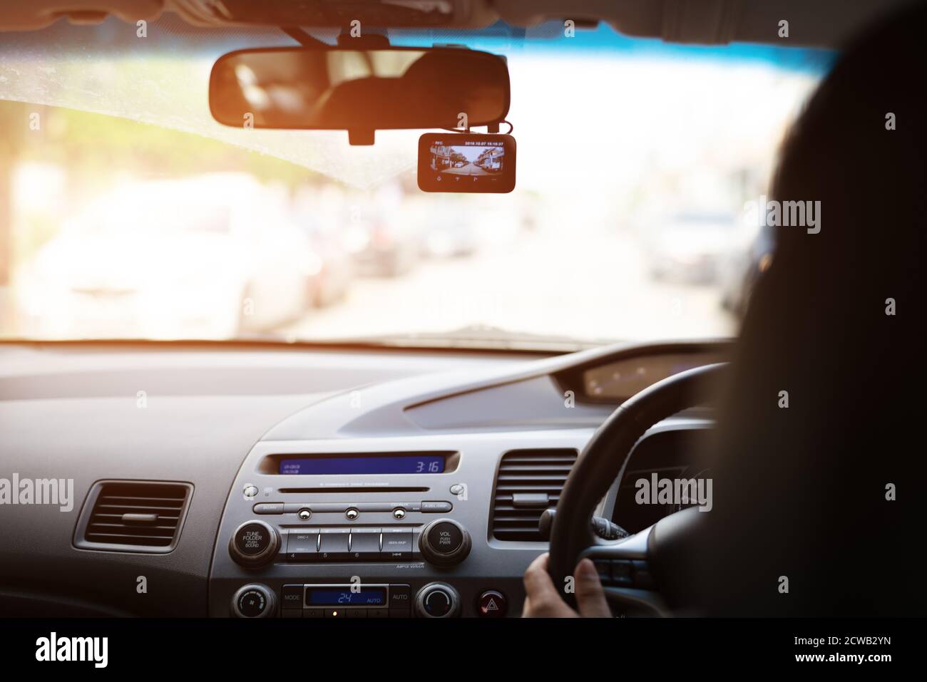 Frontkamera Auto Recorder, Frau fährt ein Auto mit Videorecorder neben einem Rückspiegel Stockfoto