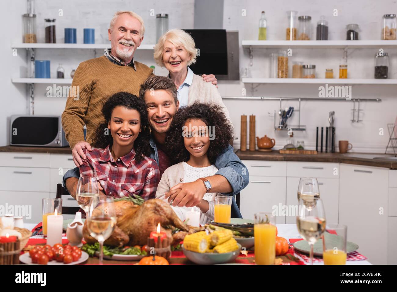Selektiver Fokus der multikulturellen Familie Umarmung während der Feier Danksagung an Zu Hause Stockfoto