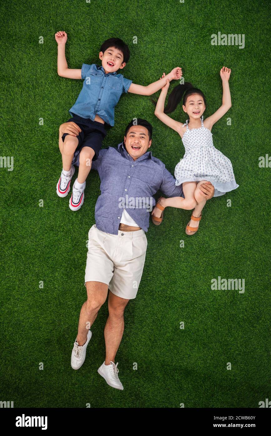 Ein Sohn und eine Tochter Vater wird auf dem getragen Gras Stockfoto