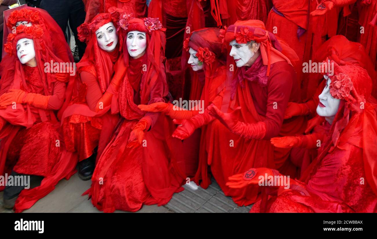 The Invisible Circus auf der Extinction Rebellion Protest 13. Oktober 2019, am Trafalgar Square im Zentrum von London . Die Gruppe Invisible Circus aus Bristol besteht aus Straßenkünstlern in roten Gewändern, die das Blut symbolisieren, das die Menschheit miteinander verbindet. Stockfoto