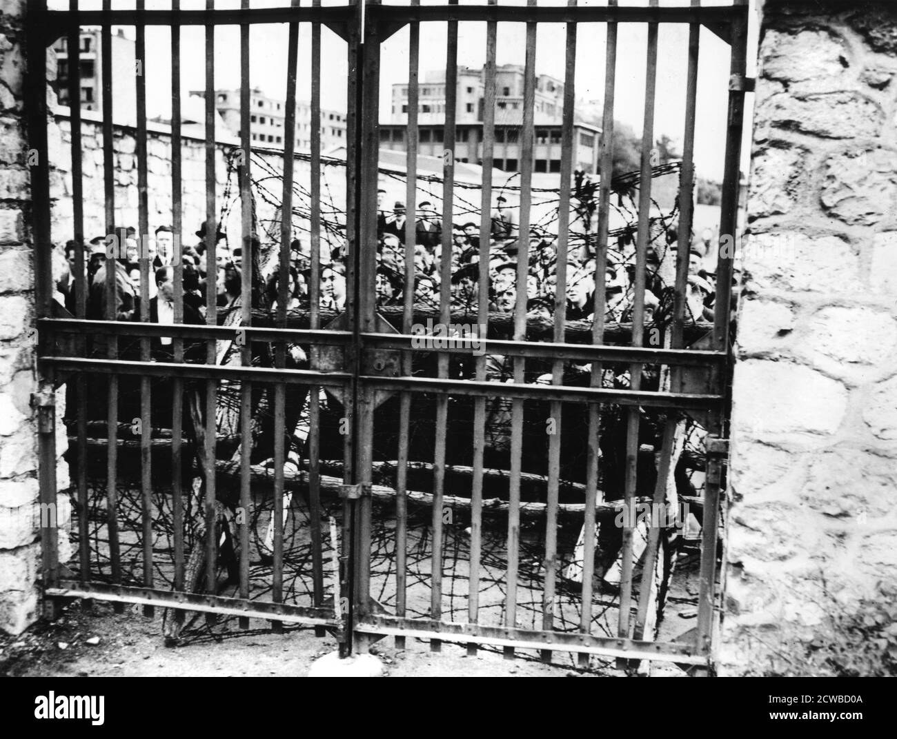 Familien warten auf die Nachricht ihrer Angehörigen, Air Ministry, Paris 1944. Die Leute warten hinter verschlossenen Toren auf die Ergebnisse der Tests, um die im Keller des Gebäudes gefundenen Leichen zu identifizieren. Der Fotograf ist unbekannt. Stockfoto