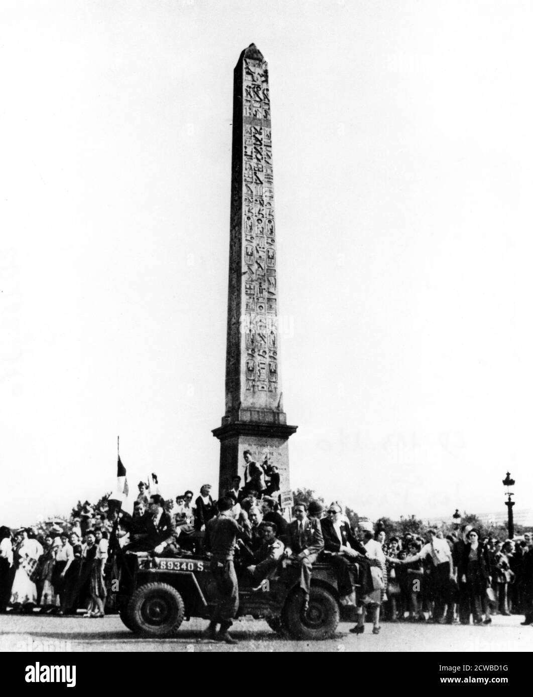 Die Befreiung von Paris, August 1944. Jubelende französische Zivilisten umgeben den Obelisk am Place de la Concorde und andere fahren auf einem amerikanischen Jeep. Die deutschen Truppen in Paris kapitulierten am 25. August 1944 den Alliierten. Der Fotograf ist unbekannt. Stockfoto