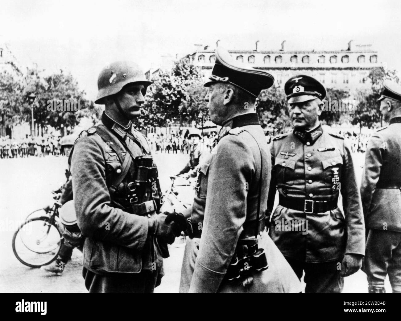 Deutsche Siegesparade nach der Eroberung von Paris, Juni 1940. General Georg von Kuechler, Kommandant der 18. Armee bei der Invasion der Niederen Länder und Frankreichs, schüttelte sich bei der Parade am Triumphbogen mit einem Soldaten die Hände. Der Fotograf ist unbekannt. Stockfoto