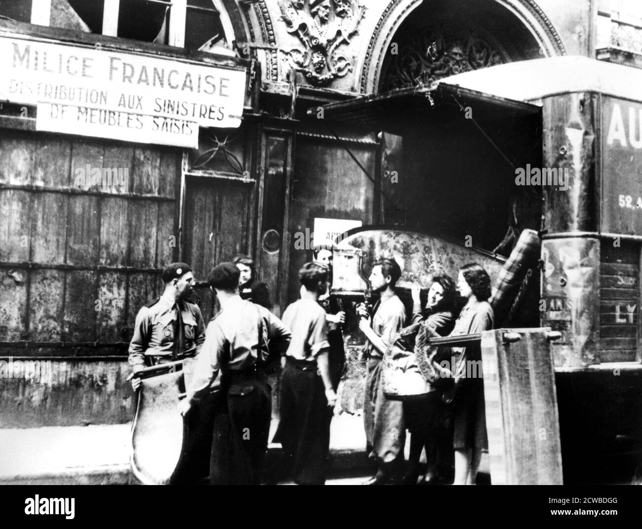 French Milice verteilt Möbel, die von Juden beschlagnahmt wurden, an die Opfer der alliierten Bombardierung, Paris, 1943-1944. Die Milice Francais war eine paramilitärische Organisation, das französische Äquivalent der deutschen Gestapo, die 1943 vor allem zum Kampf gegen den französischen Widerstand gegründet wurde. Sie waren auch aktiv an der Aufrundung der jüdischen Bevölkerung Frankreichs für die Deportation beteiligt. Der Fotograf ist unbekannt. Stockfoto