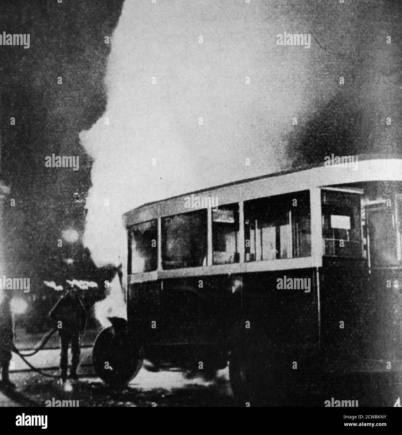 Schwarz-Weiß-Foto einer Szene aus den Demonstrationen vom 6. Februar 1934. Am Place de la Concorde steht ein Bus in Flammen. Stockfoto