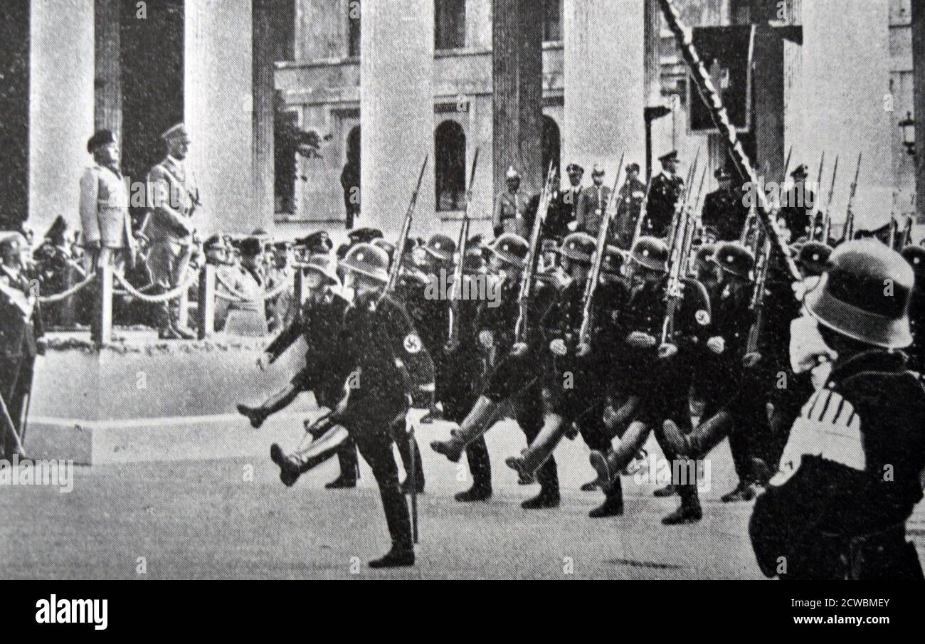 Schwarz-Weiß-Fotografie des deutschen Bundeskanzlers Adolf Hitler (1889-1945) und des italienischen Führers Benito Mussolini (1883-1945), der eine Militärparade in Berlin beobachtet. Stockfoto