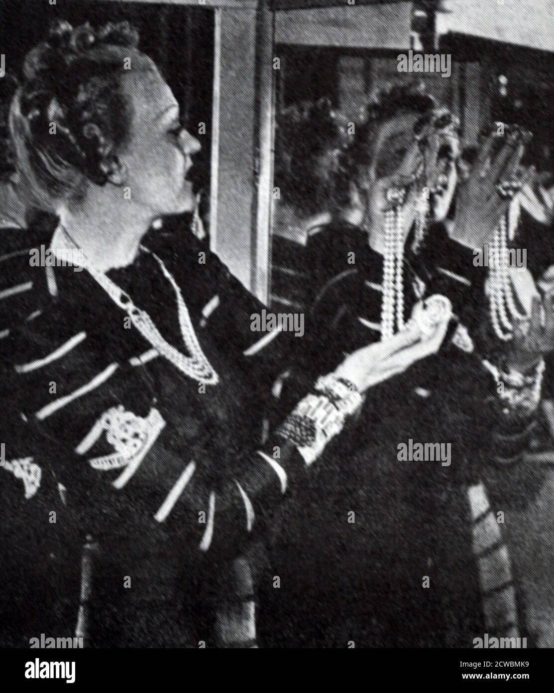Schwarz-Weiß-Fotografie der französischen Sängerin Jeanne Aubert (1900-1988) beim Versuch auf ihre Juwelen. Stockfoto